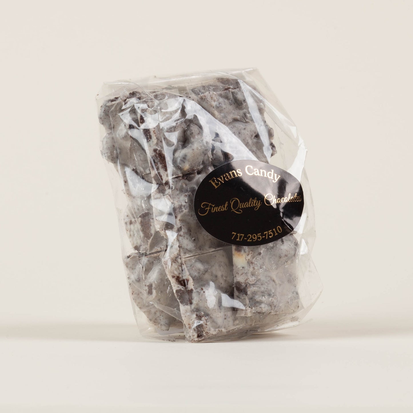 Eight-ounce bag of Evans Candy Cookies and Cream Bark on a light background, handmade chocolate bark with crushed Oreo cookies made in Lancaster, PA.