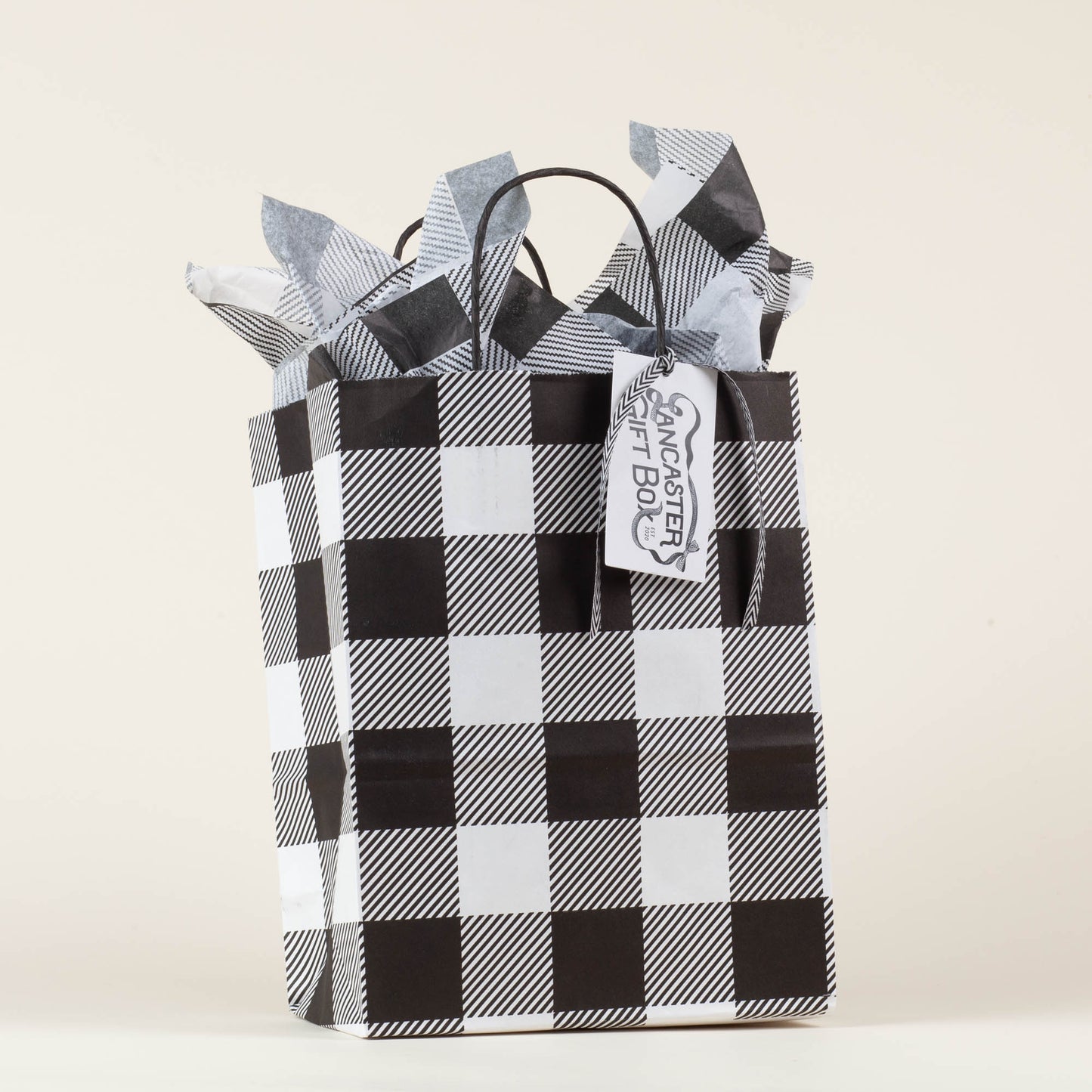 Lancaster Gift Box event bag in signature black and white gingham with gift tag on a light background.