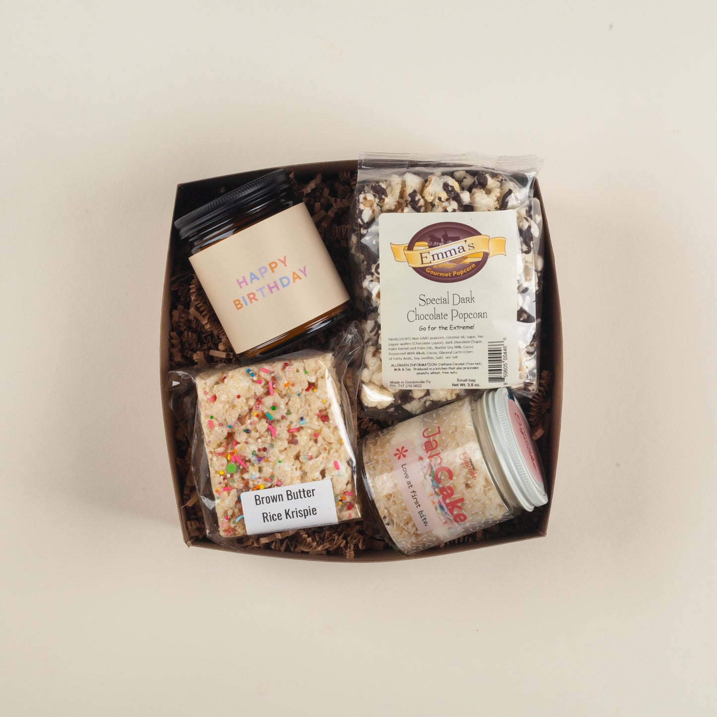Festive Pennsylvania birthday gift box with a Happy Birthday candle, rich dark chocolate popcorn, buttery sprinkle rice krispie & vanilla jarcake.