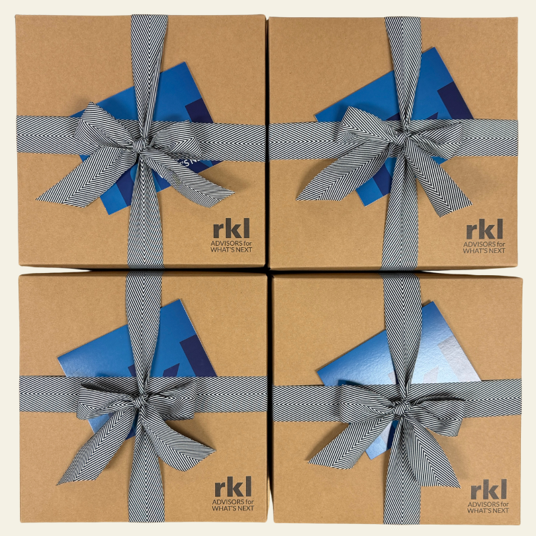 Four brown boxes with blue cards and gray ribbons, featuring the 'rkl' logo.