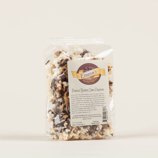 Small bag of Emma's Peanut Butter Oreo popcorn on a light background, chocolate-drizzled popcorn with crushed Oreo cookies and sea salt, made in Lancaster County, PA.