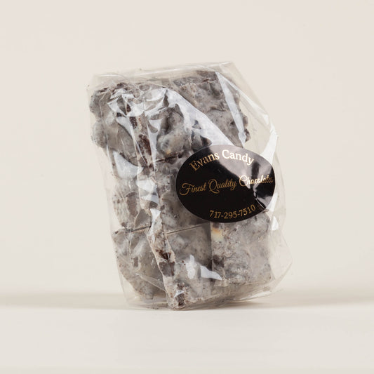 Eight-ounce bag of Evans Candy Cookies and Cream Bark on a light background, handmade chocolate bark with crushed Oreo cookies made in Lancaster, PA.