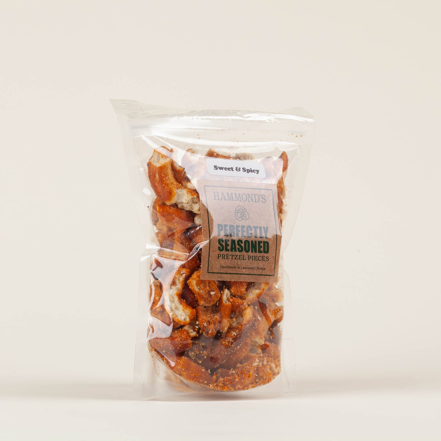Eight-ounce bag of Hammond's Sweet & Spicy Pretzel Pieces on a light background, crunchy paprika-seasoned sourdough pretzel pieces made in Lancaster, PA.