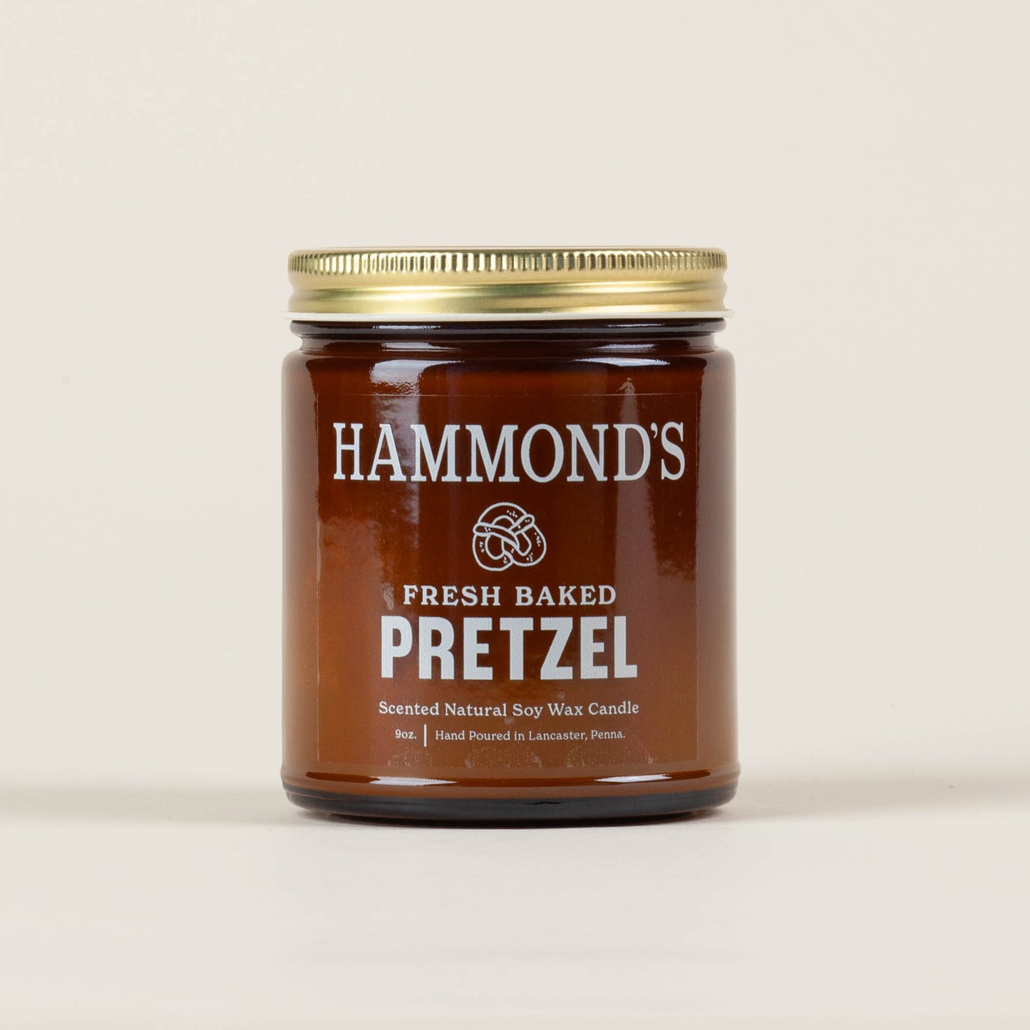 Nine-ounce Hammond's Fresh Baked Pretzel soy wax candle on a light background, hand poured by Christina Maser Company, capturing the warm aroma of Lancaster's oldest pretzel bakery.