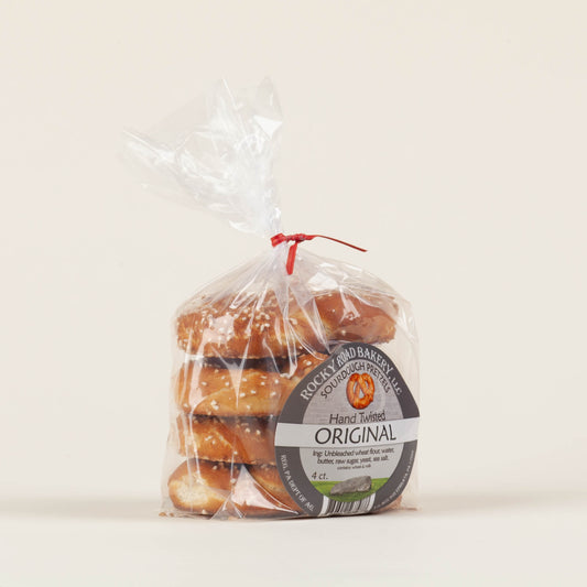 4-pack of Rocky Road Bakery hand-twisted sourdough pretzels on a light background, buttery small-batch hard pretzels made on a Mennonite family farm in Ephrata, Lancaster County, PA.