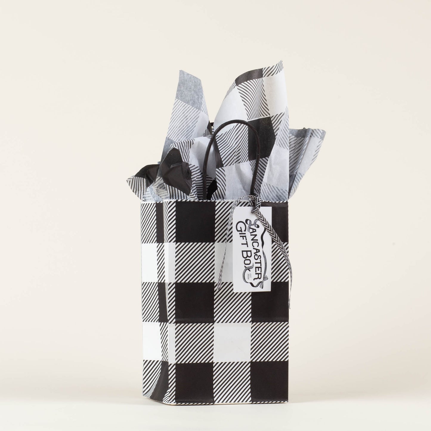 Lancaster Gift Box event bag in signature black and white gingham with gift tag on a light background. 