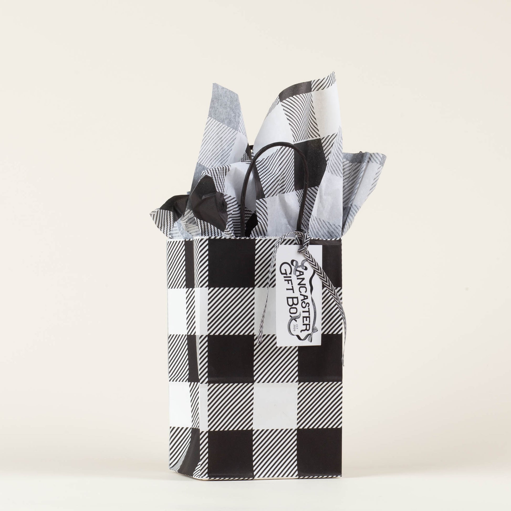 Lancaster Gift Box event bag in signature black and white gingham with gift tag on a light background. 